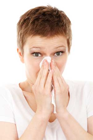 Woman with Nasal Congestion Blowing her Nose